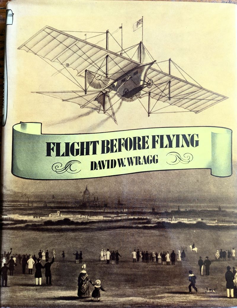 Picture of book dust jacket showing primitive ( fanciful) aeroplane flying above onlooking crowd